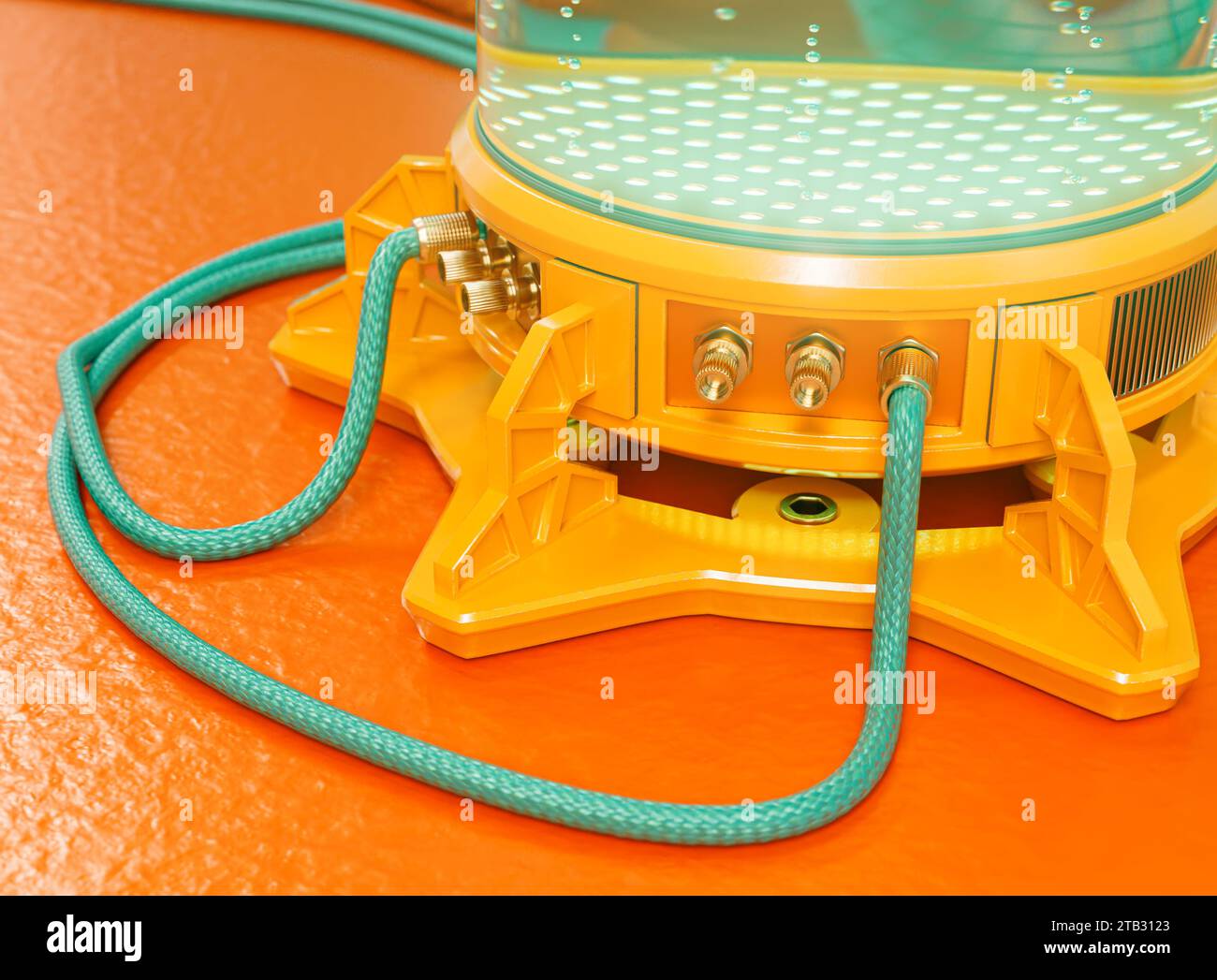 A brightly colored futuristic concept science lab cryogenic test tube machine filled with liquid and bubbles with connected cables and rubber pipes - Stock Photo