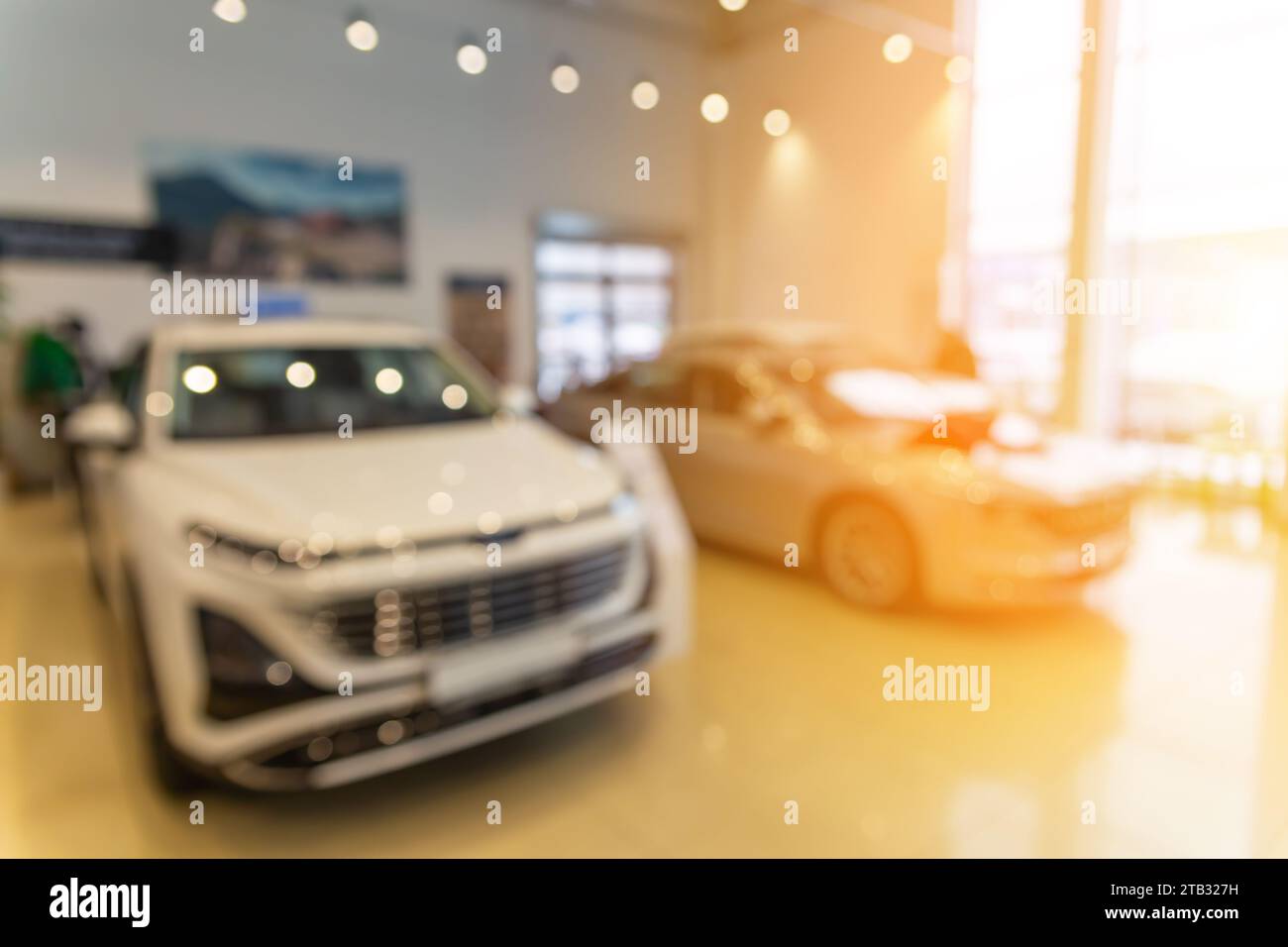 Blurred new car parked in modern showroom waiting for sales. Abstract background of blurred new cars dealership place. Stock Photo