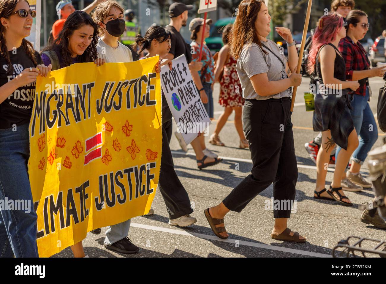 Vancouver, Canada - September 15,2023: Young activists with a sign: Migrant Justice Climate Justice walking down Cambie Street as part of the Global C Stock Photo