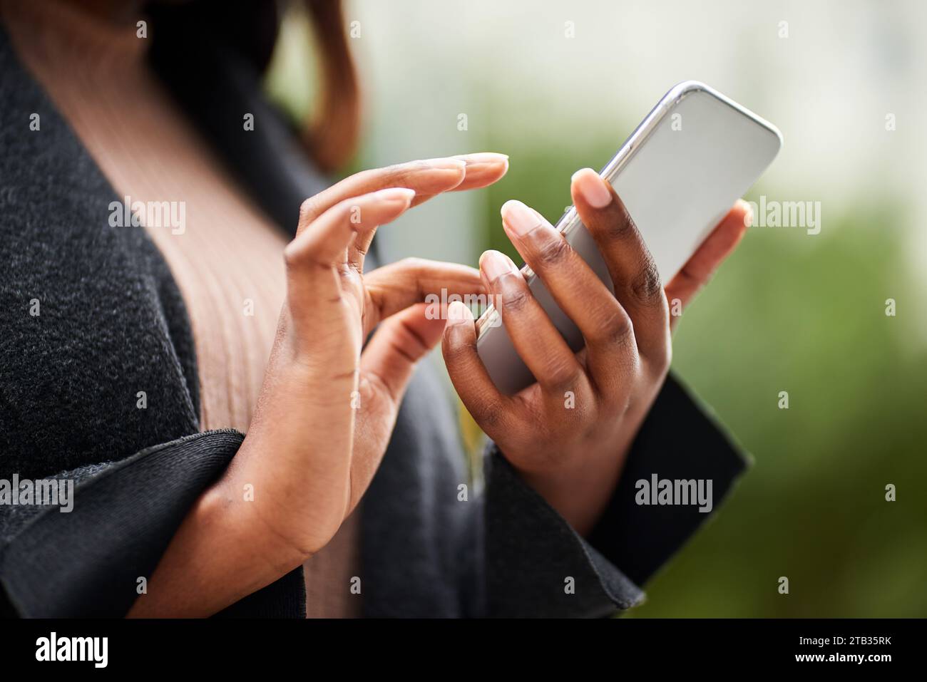 Cropped image of young Black woman hands in business wear holding cell phone Stock Photo