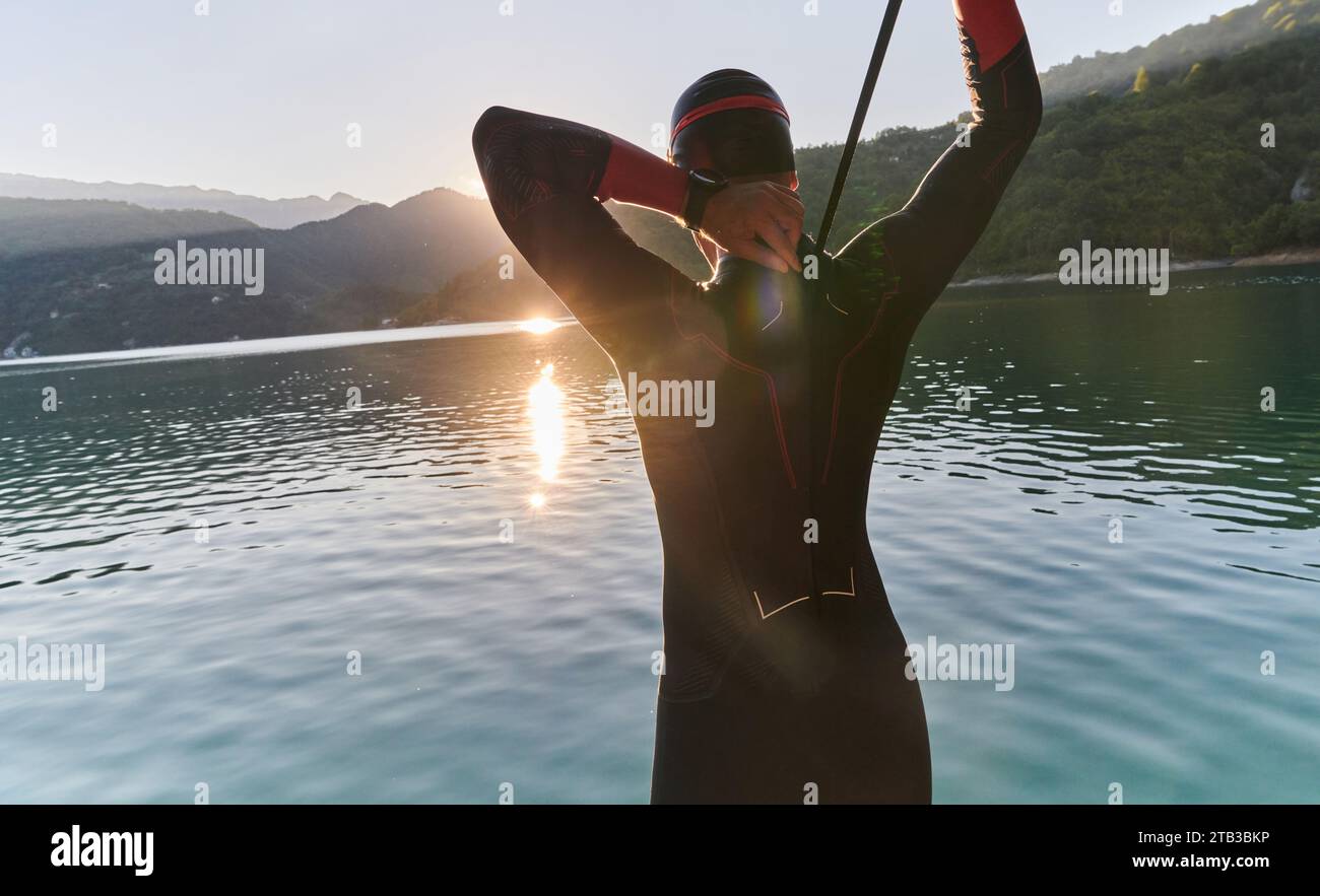 Swimmer Getting Ready Authentic triathlon athlete getting ready for swimming training on lake ...