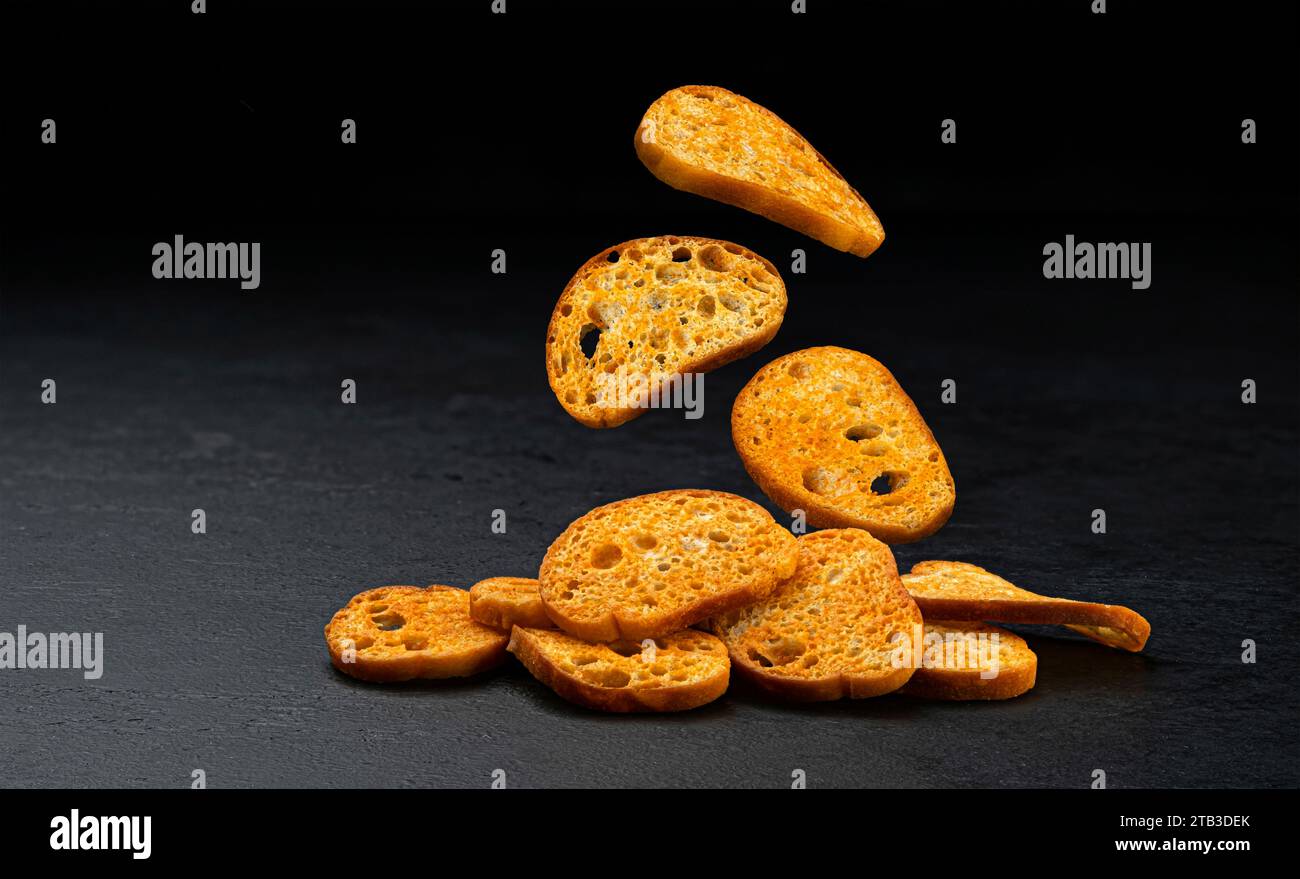 Bruschetta crackers, round bread croutons isolated on black background Stock Photo