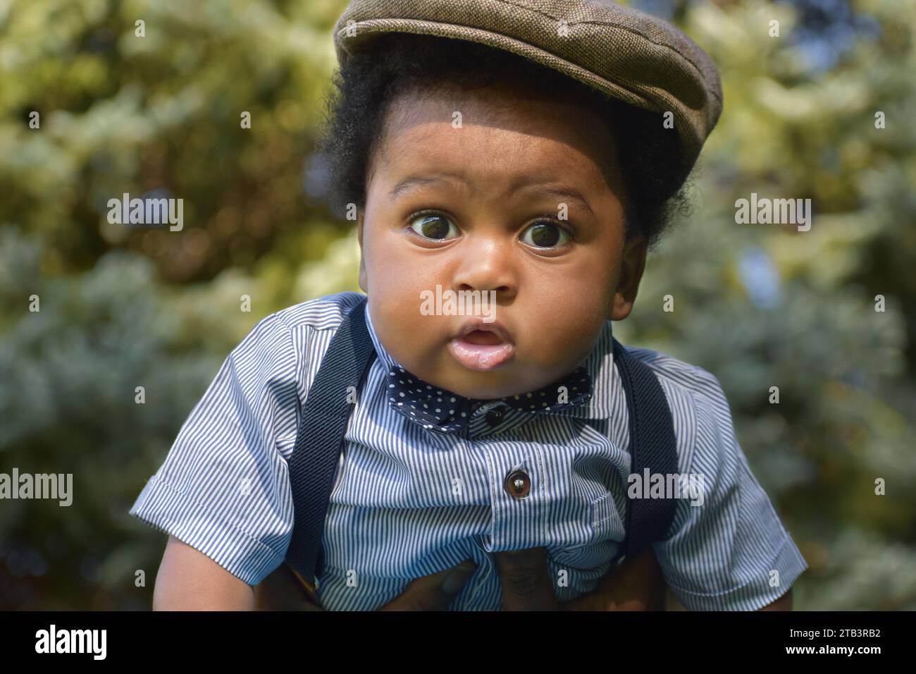 Adorable Cute baby boy in hat, drooling, black baby boy Stock Photo