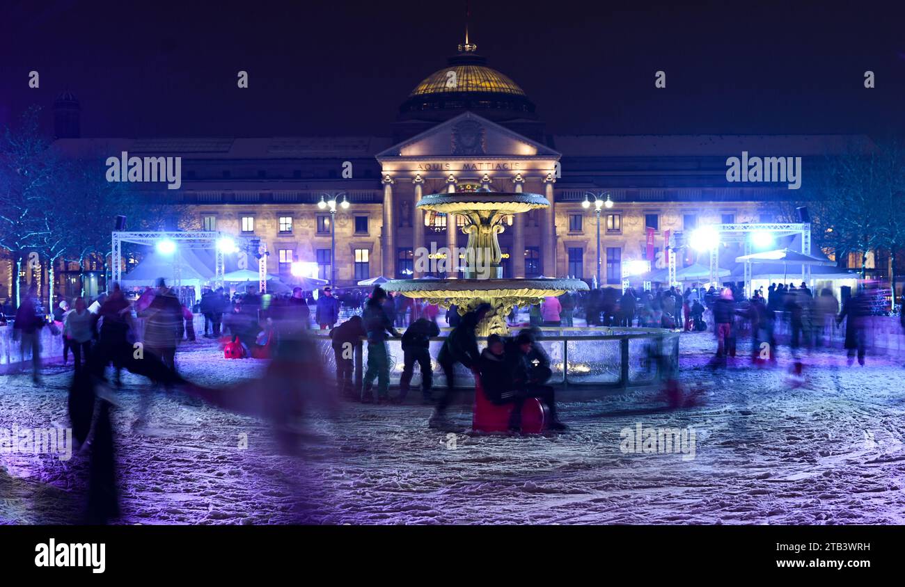 Wiesbaden, Germany. 04th Dec, 2023. Ice skaters are out and about on Germany's largest mobile ice rink on the bowling green in front of the Kurhaus in the evening (shot with slower shutter speed). Until January 14, 2500 square meters of 'icy' fun is on offer. Credit: Arne Dedert/dpa/Alamy Live News Stock Photo