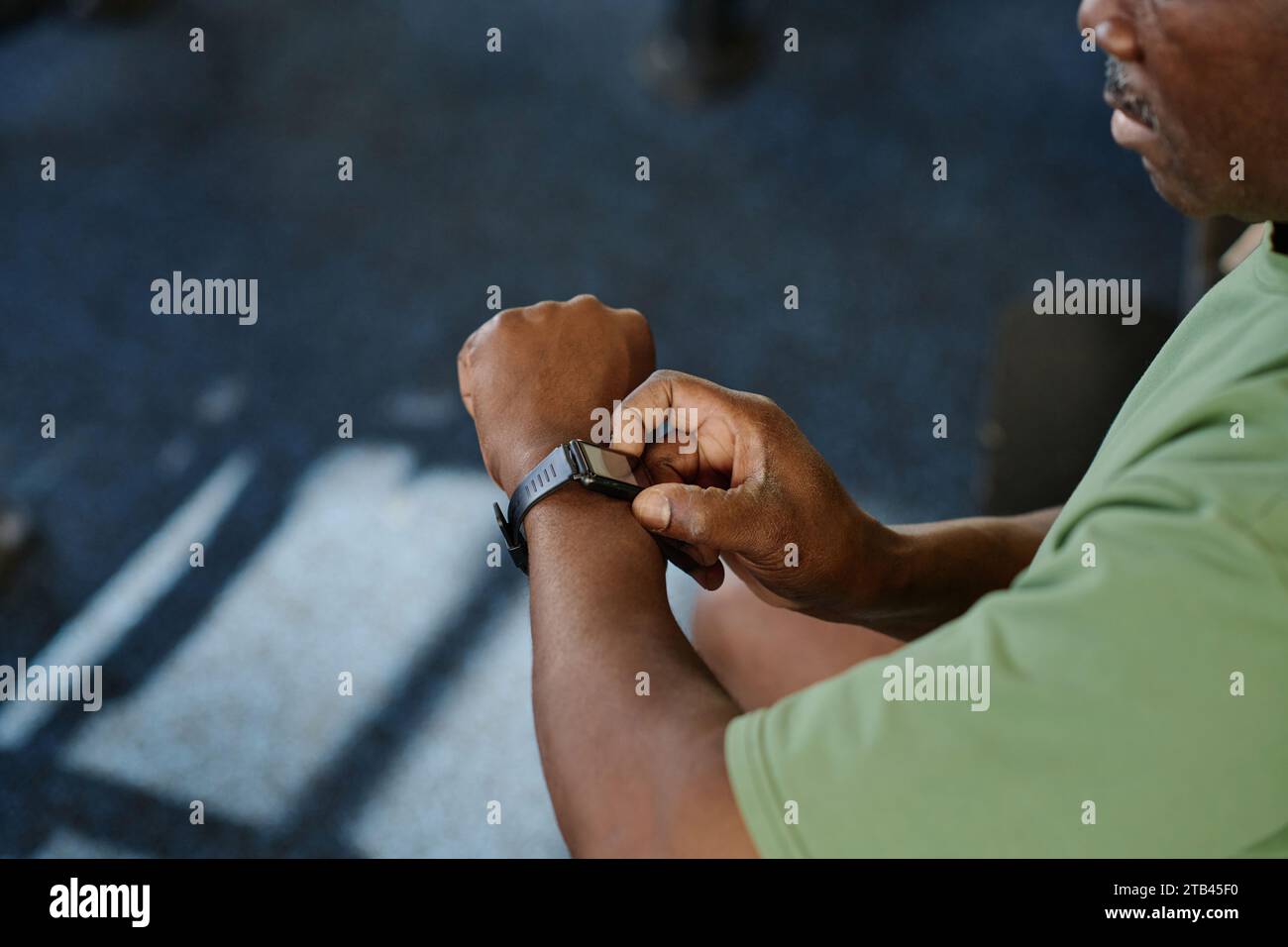 Medium closeup of unknown african american man pushing side buttons of his smartwatch, copy space Stock Photo