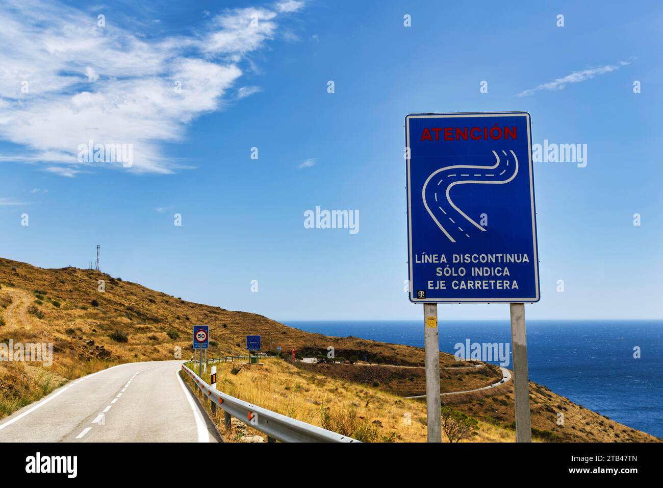 Winding road, mountain pass Coll dels Belitres, traffic sign warns on the coastal road from Portbou to Cerbere, border crossing between Spain and Stock Photo