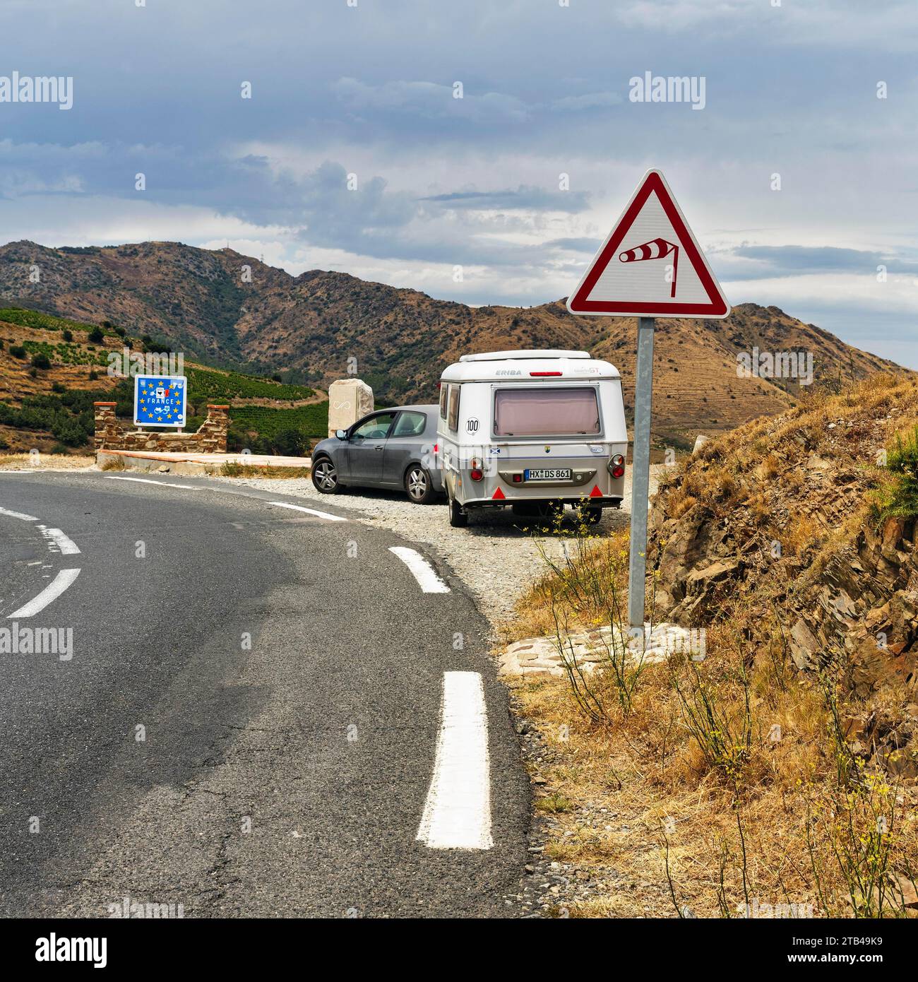 Border crossing, mountain pass Coll dels Belitres, traffic sign warns of wind, crosswind from the right, coastal road from Portbou to Cerbere Stock Photo