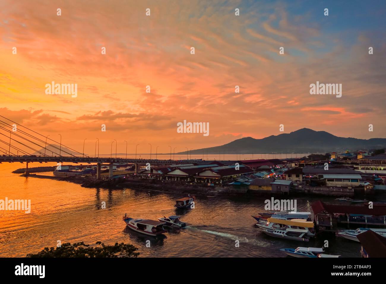 Manado port & Soekarno Bridge at sunset in the provincial capital of Sulawesi's far north. Manado, North Sulawesi, Indonesia. Stock Photo