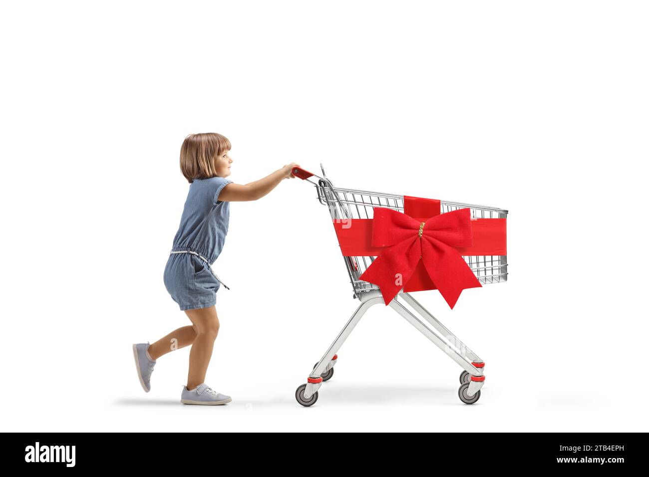 Full length profile shot of a little girl pushing a big empty shopping