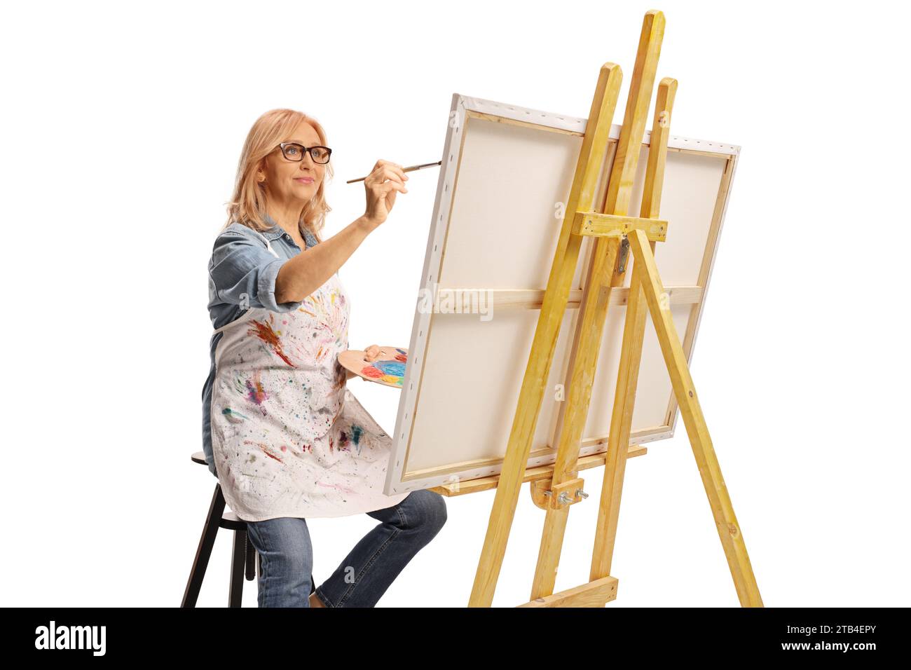 Female artist with a brush and palette painting on a canvas isolated on ...