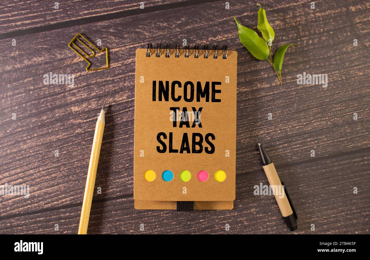 Income Tax Slabs inscription on white card. Workplace background, top view Stock Photo