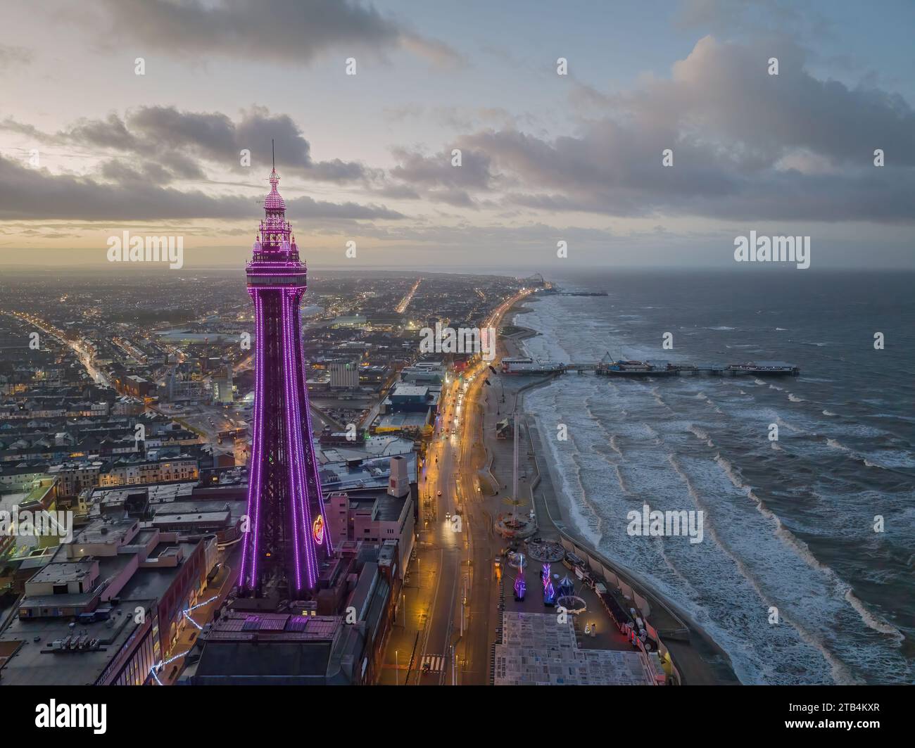 Blackpool, Lancashire, United Kingdom.Blackpool sea front and tower aerial view at dusk with illuminations looking towards the pier and pleasure beach Stock Photo