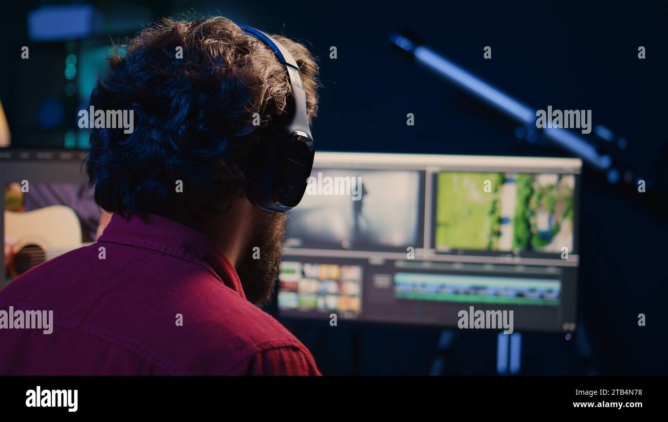 Video editor using editing software to upgrade footage shot, commissioned by production teams outsourcing tasks. Freelancer videographer finishing project in apartment studio Stock Photo