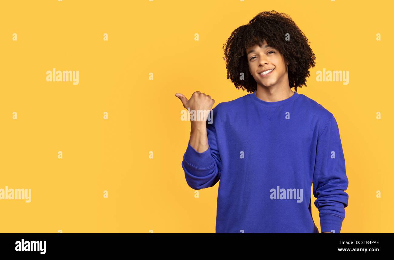 Handsome Black Guy Pointing Aside At Copy Space With Hand Stock Photo