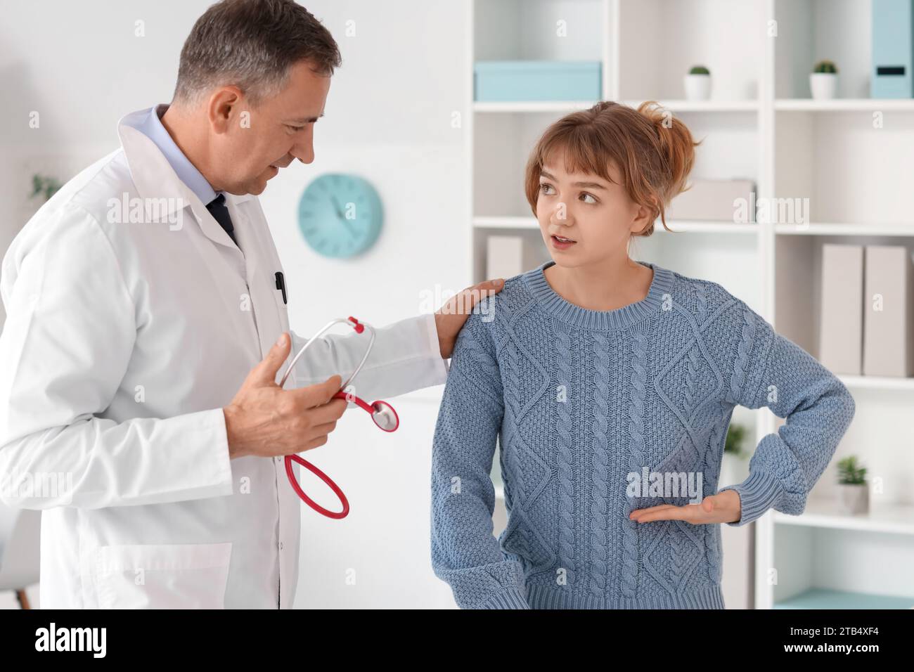 Mature doctor talking with patient in medical office Stock Photo