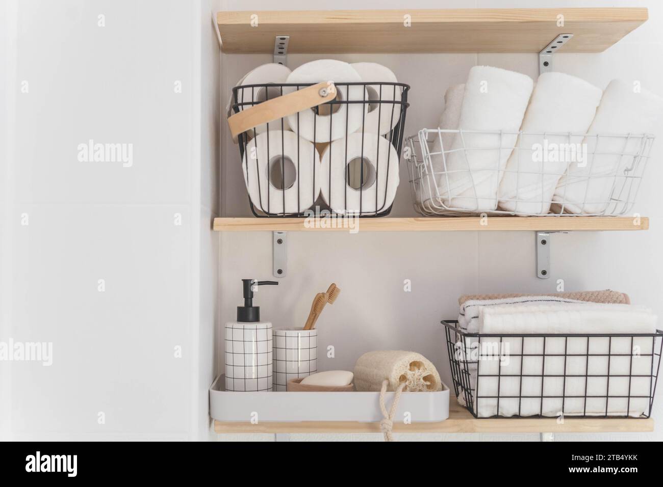 https://c8.alamy.com/comp/2TB4YKK/beautiful-white-bathroom-wooden-shelves-rolled-towels-stacked-towels-and-baskets-2TB4YKK.jpg