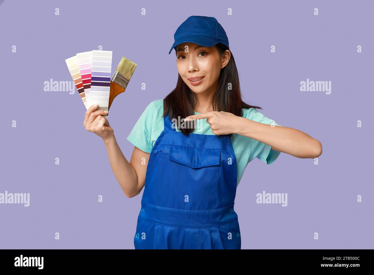 Female Asian painter pointing at brush and paint color palettes on ...