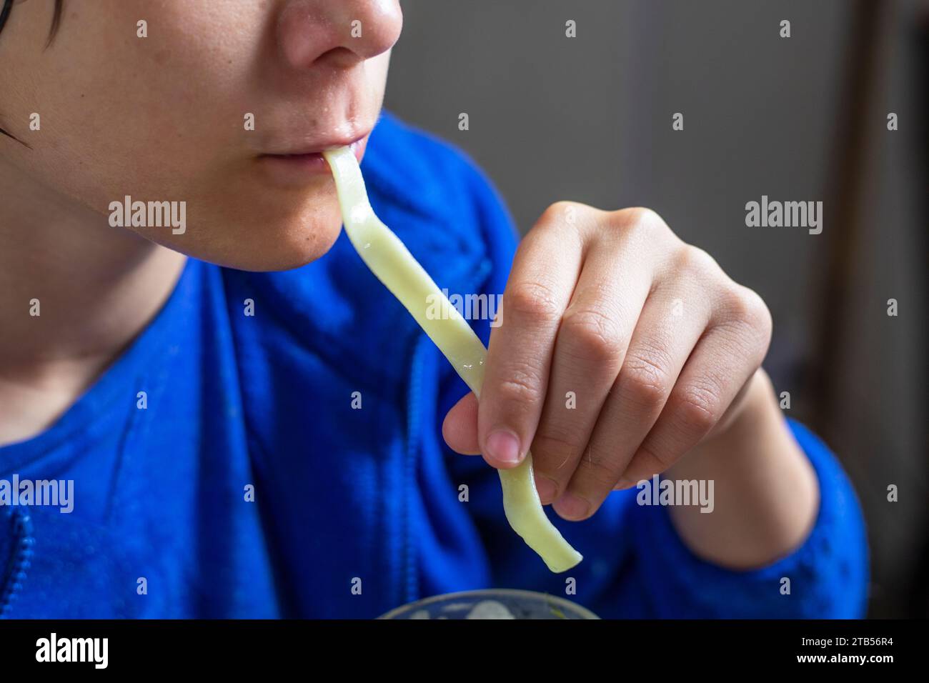 boy eats homemade noodles with long hands Stock Photo Alamy