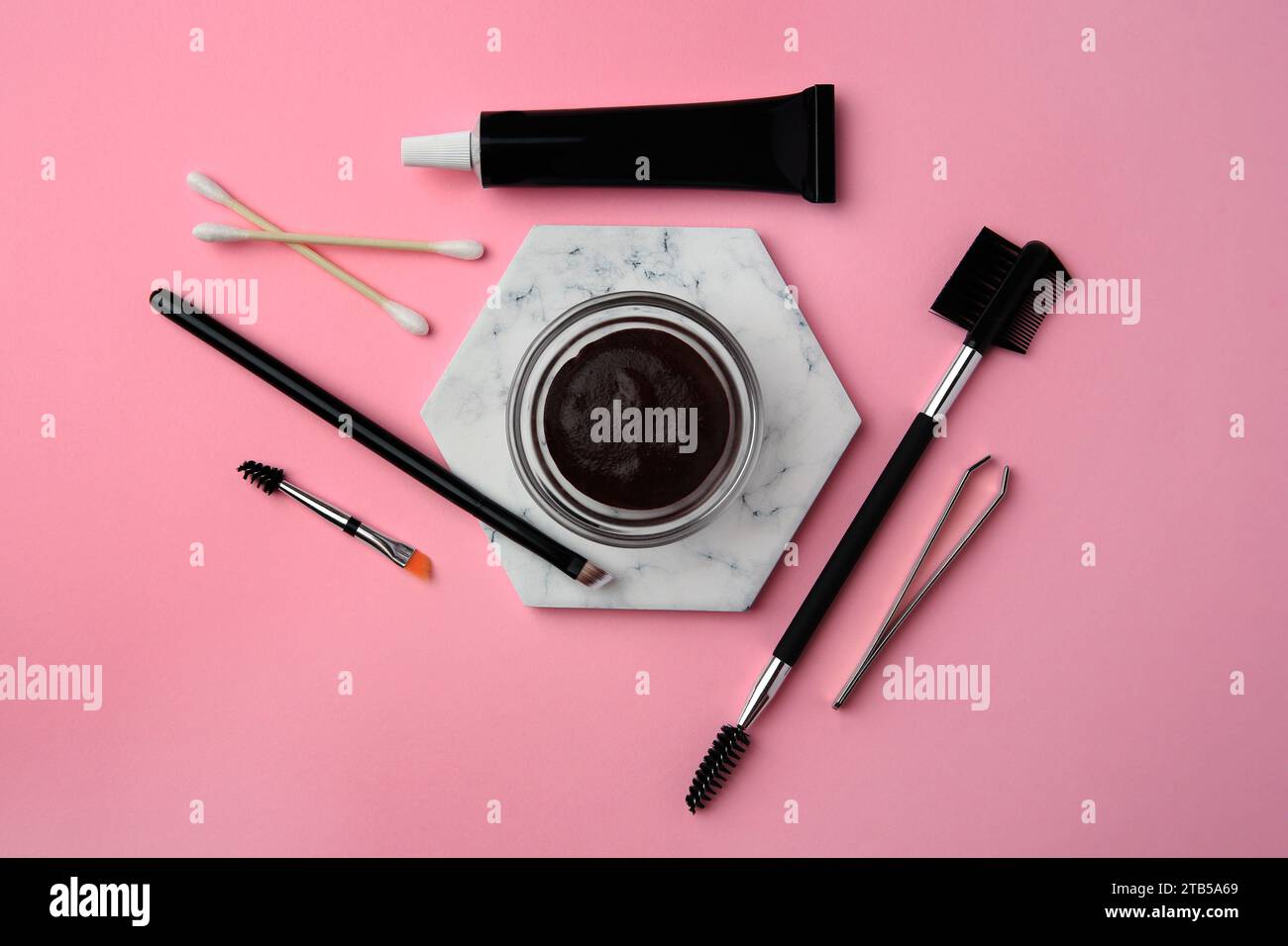 Flat lay composition with eyebrow henna and tools on pink background Stock Photo