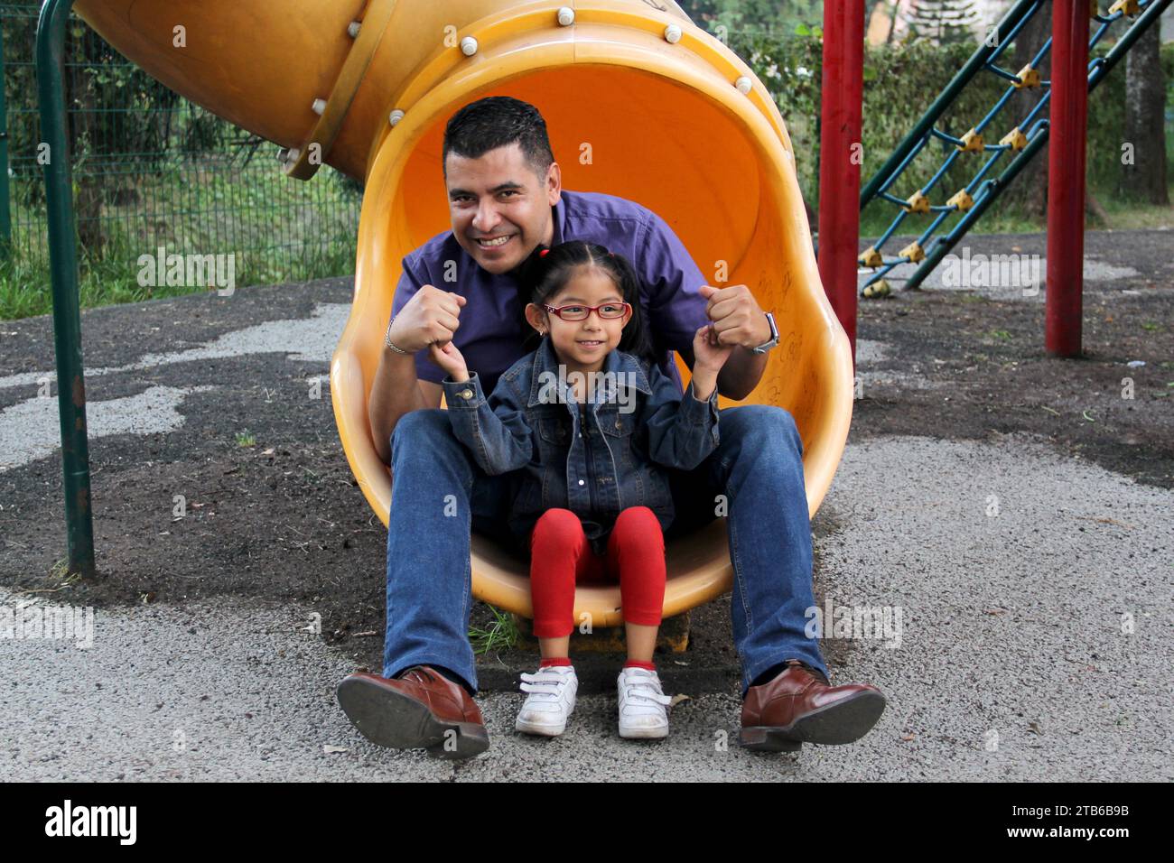 Divorced single dad and brown latino 4 year old daughter spend quality time playing on park games living in poverty Stock Photo