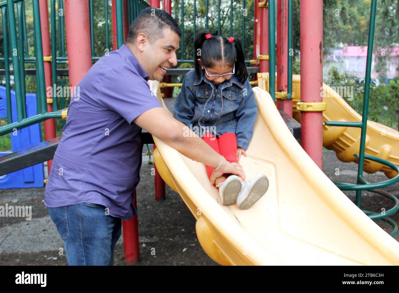 Divorced single dad and brown latino 4 year old daughter spend quality time playing on park games living in poverty Stock Photo