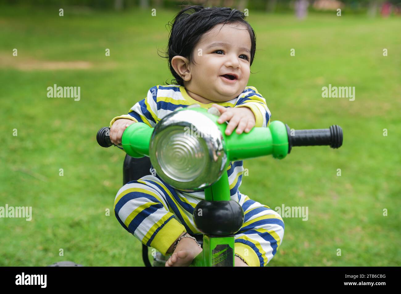 Cute little toddler rides the tricycle. Toddler using bike at park or