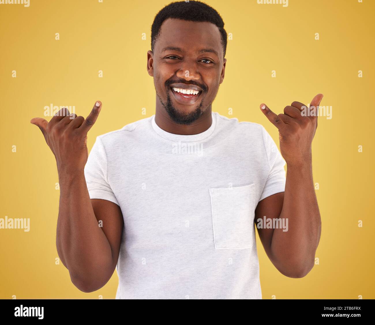 Man, portrait and cool hand gesture in studio on yellow background for hang loose, good mood or relax weekend. Black person, model and face for finger Stock Photo