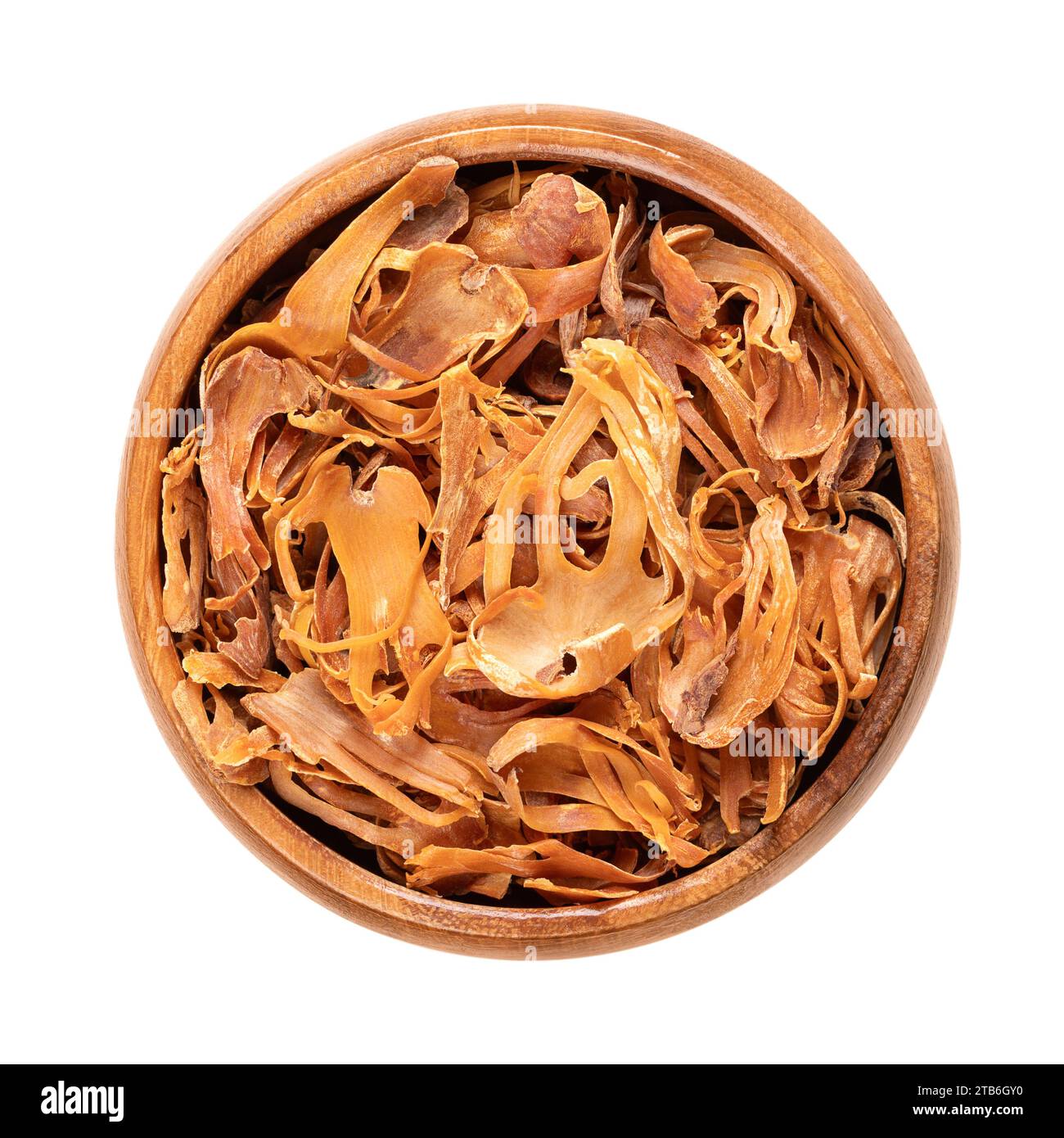 Dried mace in a wooden bowl. Spice with pale yellow and orange tan, made of seed coverings of nutmeg seeds, with similar flavor, but more delicate. Stock Photo