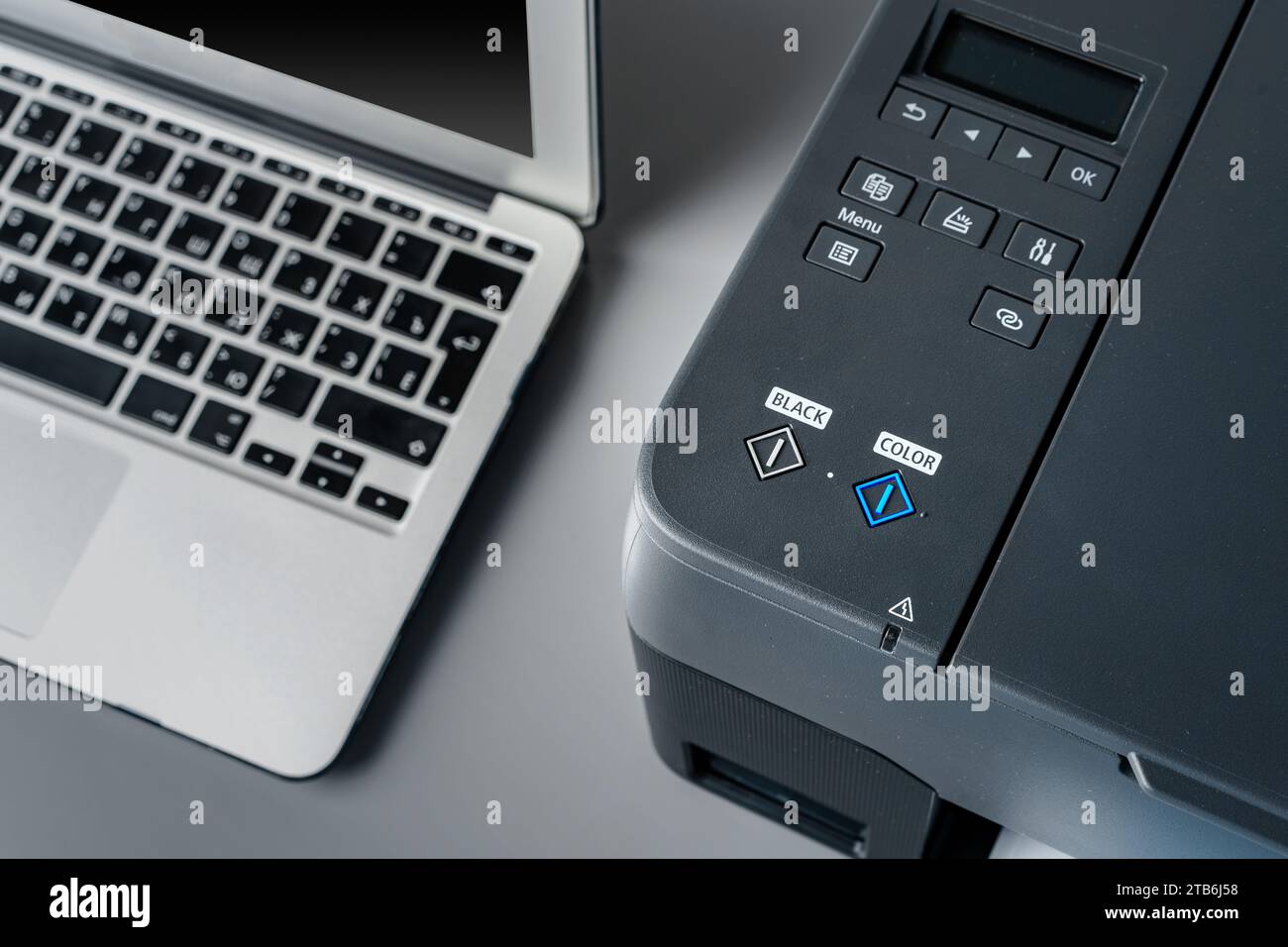 Printer and laptop on grey table in office Stock Photo
