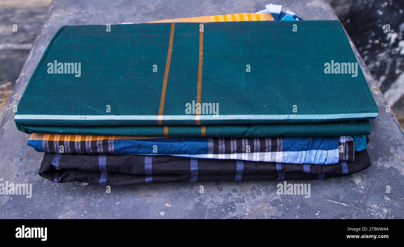 Folded Cotton Fabric Lungi on dark Concrete floor Traditional Men's Fashion Lifestyle in Bangladesh Stock Photo