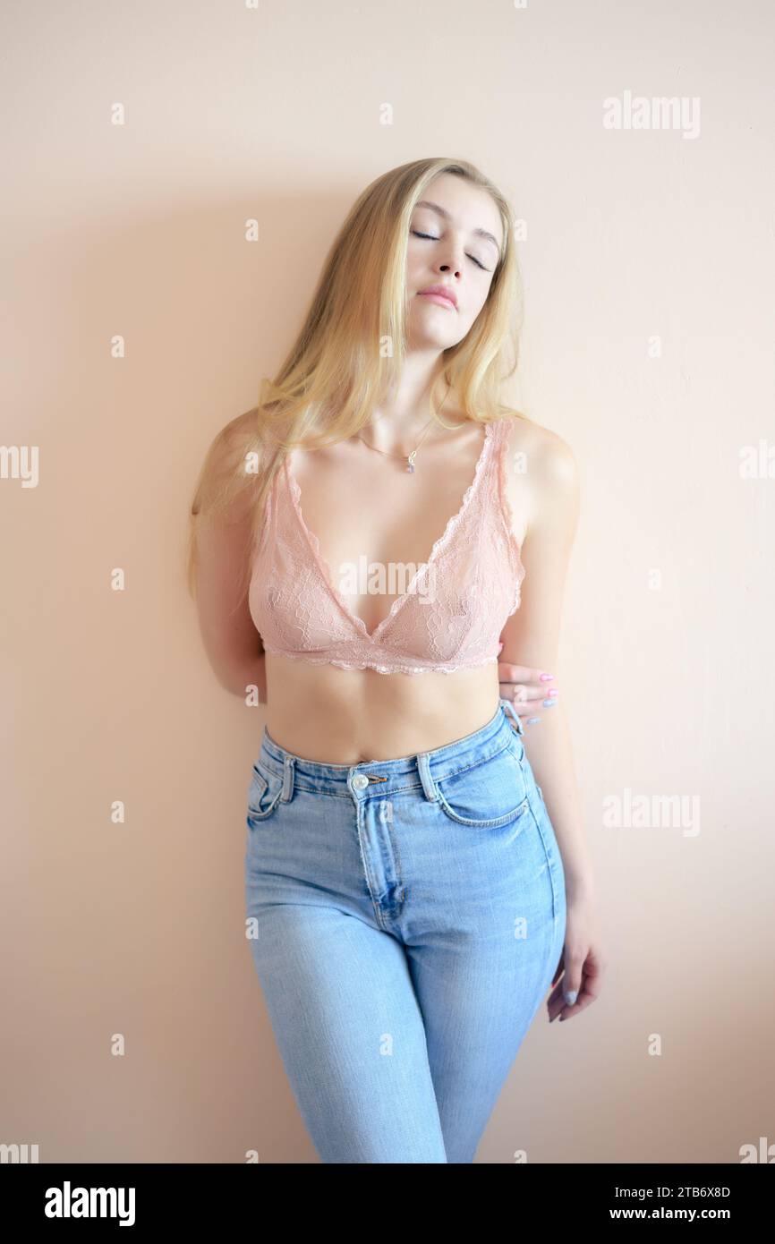 Young beautiful woman wearing pink top lingerie with denim short pants in  studio lighting Stock Photo