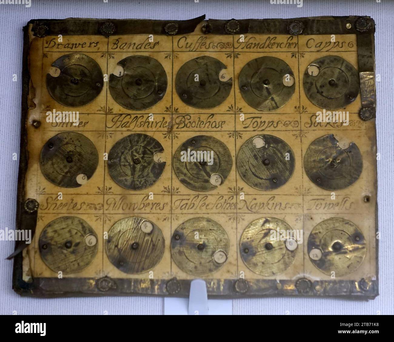 Washing tally, England, 1600-1700, oak board, brass, horn, printed sheet covered with talc Stock Photo