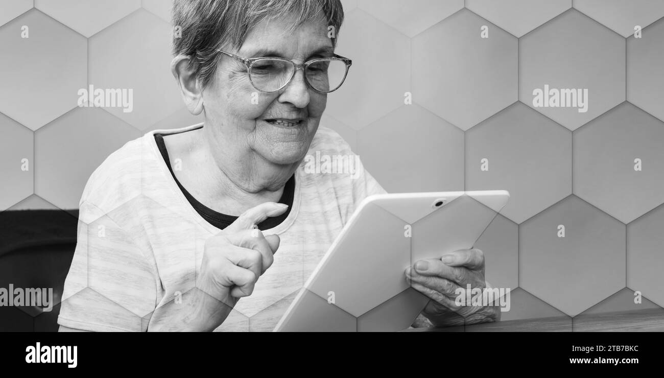 Senior woman using a tablet, geometric pattern Stock Photo