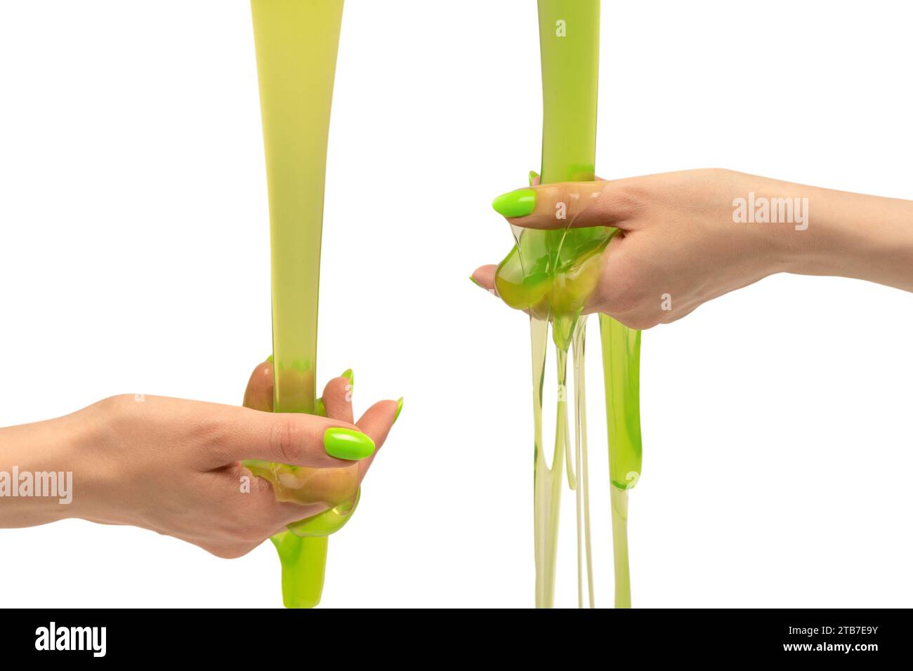 Green slime toy in woman hand with green nails isolated on a white background. Stock Photo