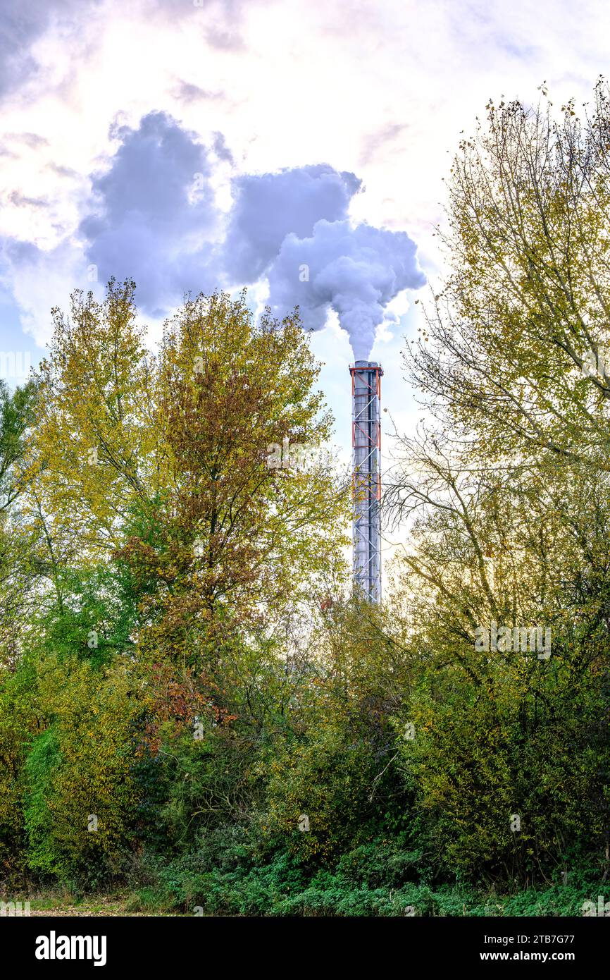 Symbolic image, emission of exhaust fumes from the chimney of an industrial plant into the environment. Stock Photo