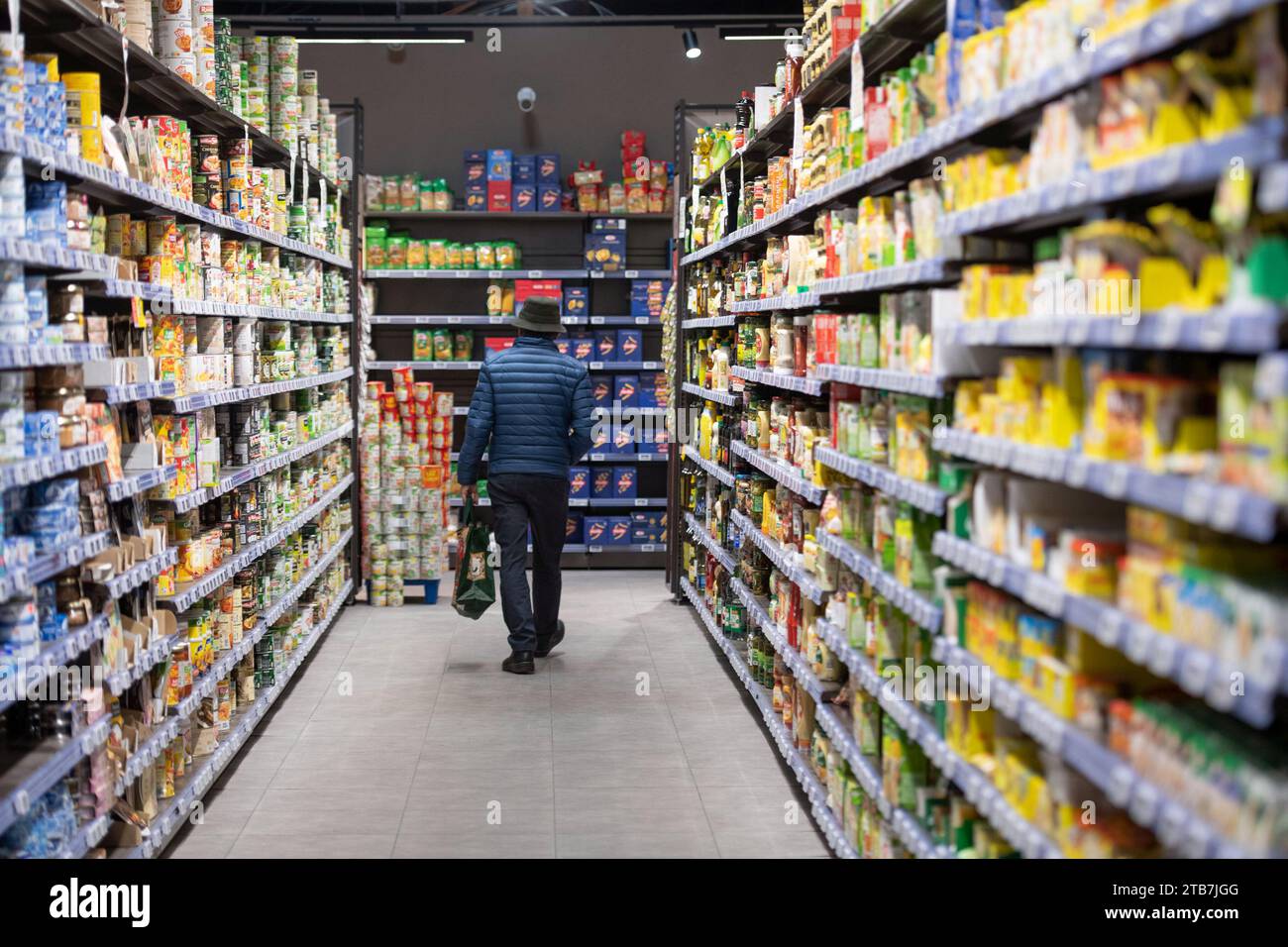 man viewed from behind doing some shopping in the tinned food section *** Local Caption *** Stock Photo