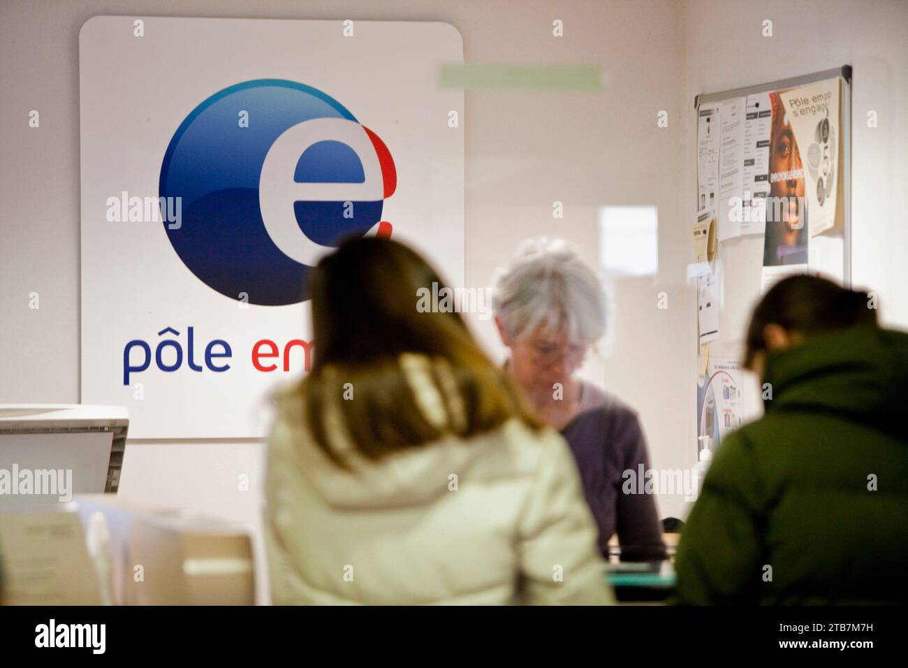 Job center “Pole emploi” in Gap (south-eastern France): advisors at the reception desk and job seekers, Pole Emploi logo Stock Photo