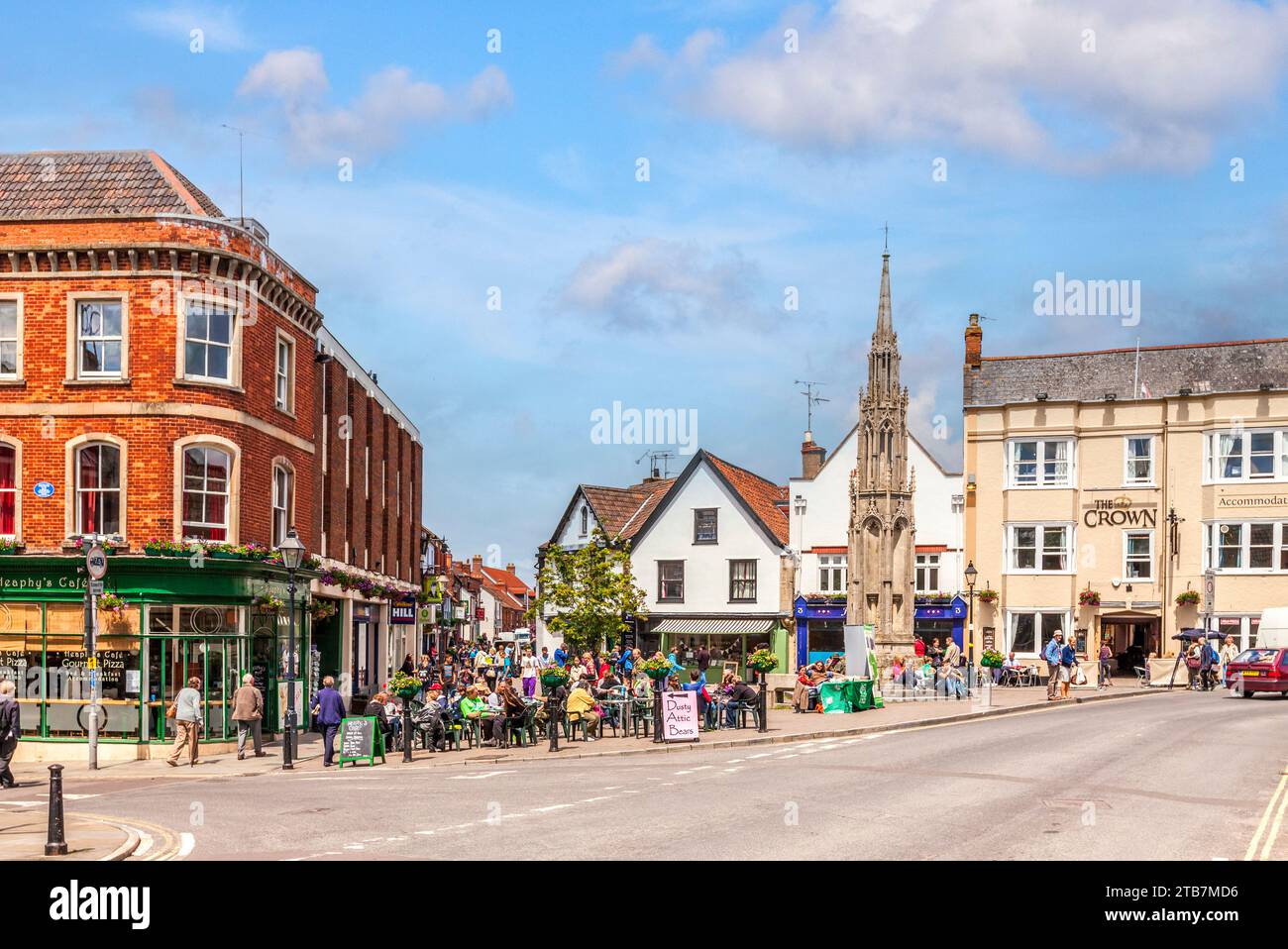 10 June 2011: Glastonbury, Somerset - The centre of Glastonbury on a bright sunny day.  People are seated at a pavement cafe, and shops and a pub... Stock Photo
