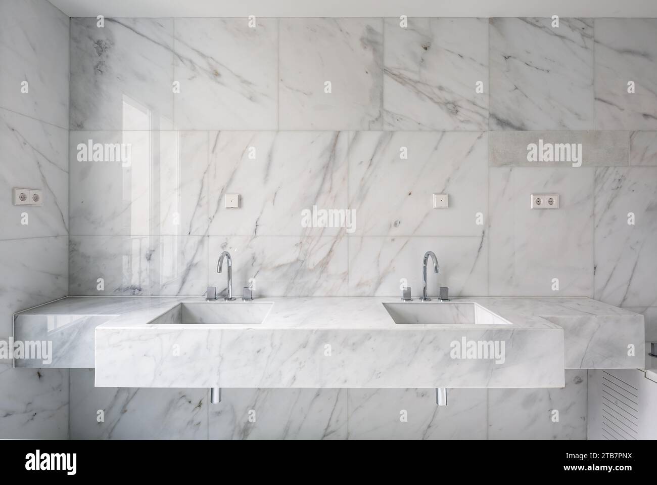 View of Modern white marble double washbasins with stainless steel faucets in ...