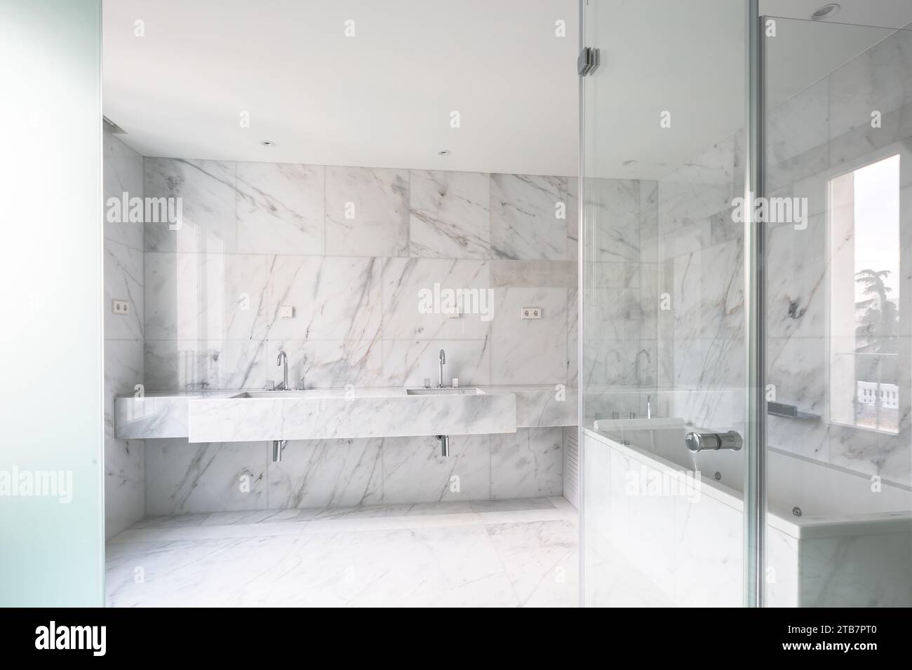 Interior of spacious bathroom with shower cabin and double washbasins ...