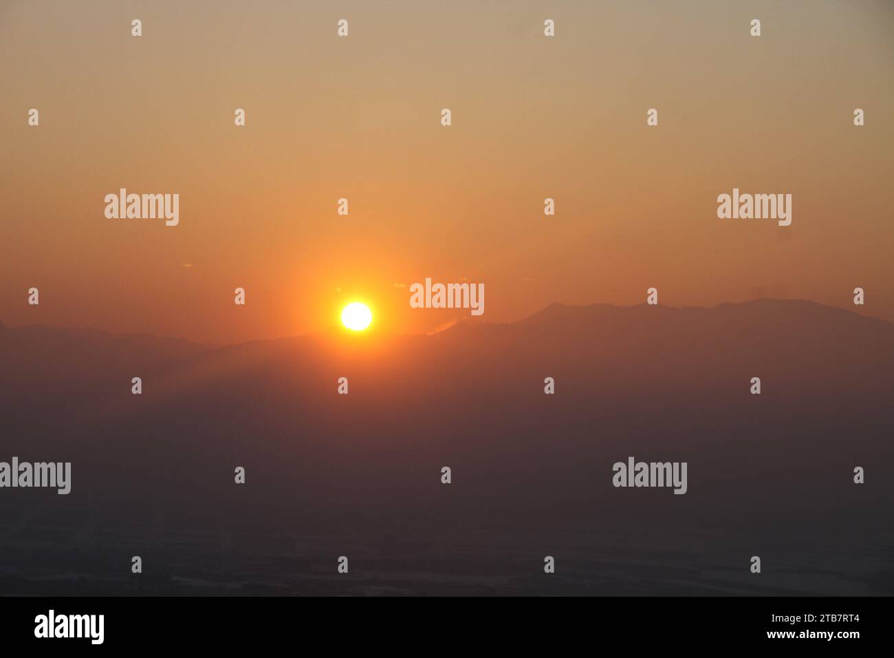 A view of the sunset sky behind mountains | red sky Stock Photo - Alamy