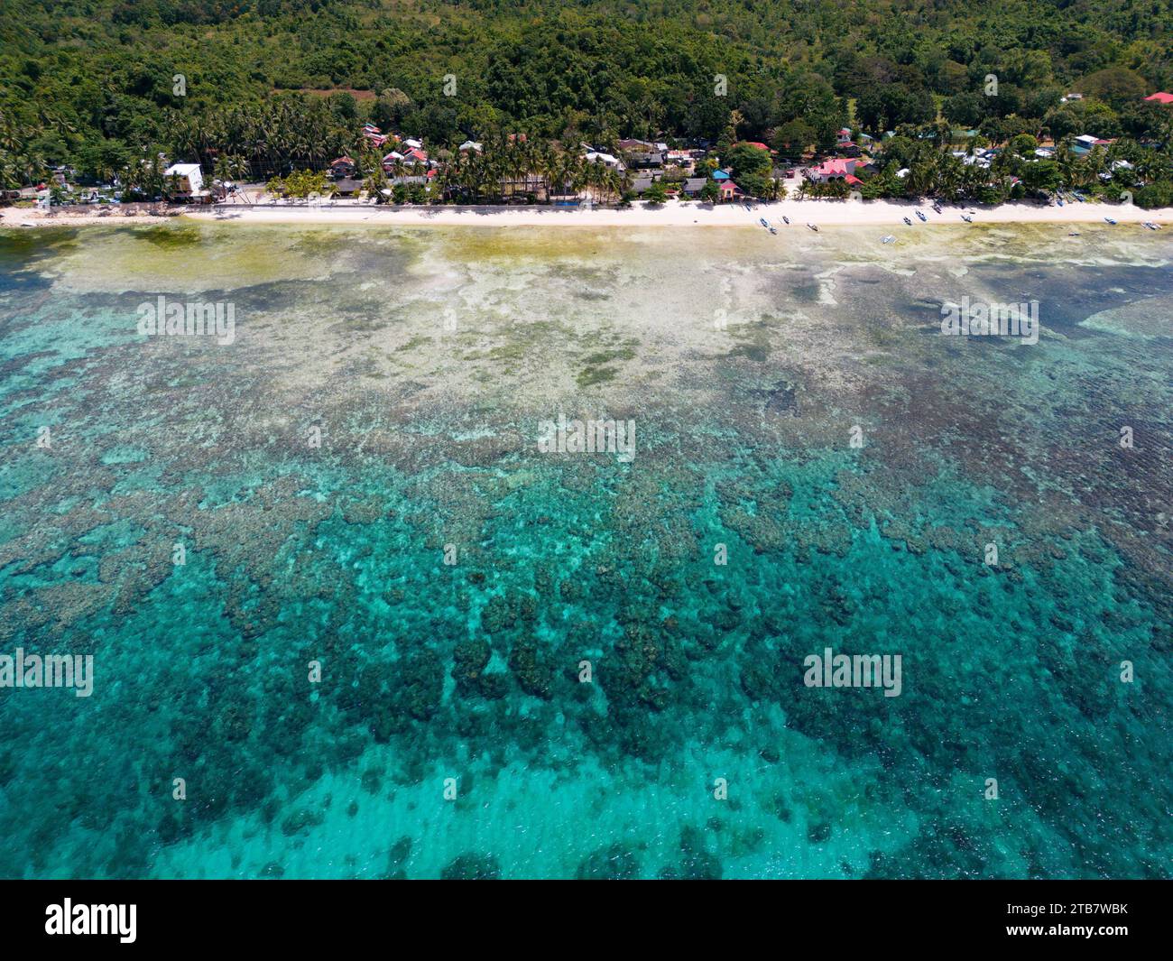 An idyllic beach scene with crystal-clear turquoise waters of Maite Marine Sanctuary, Siquijor, Philippines Stock Photo