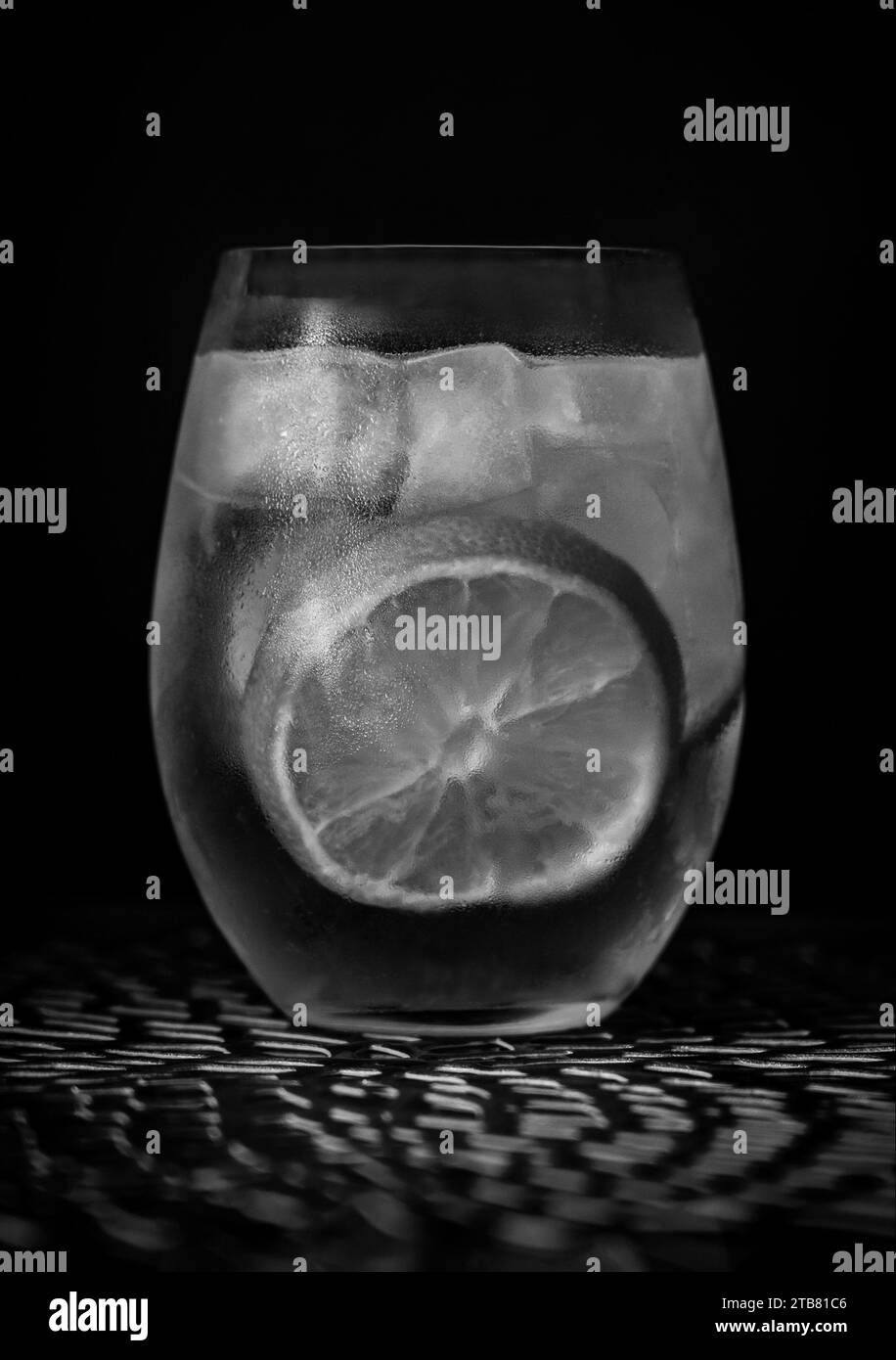 Gin and Tonic cocktail in black and white with ice and lemon Stock Photo