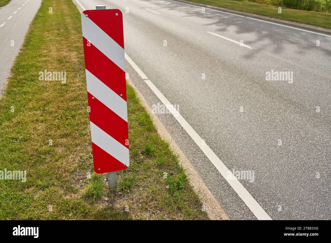 Red and white striped traffic sign on road as safety warning in summer Stock Photo