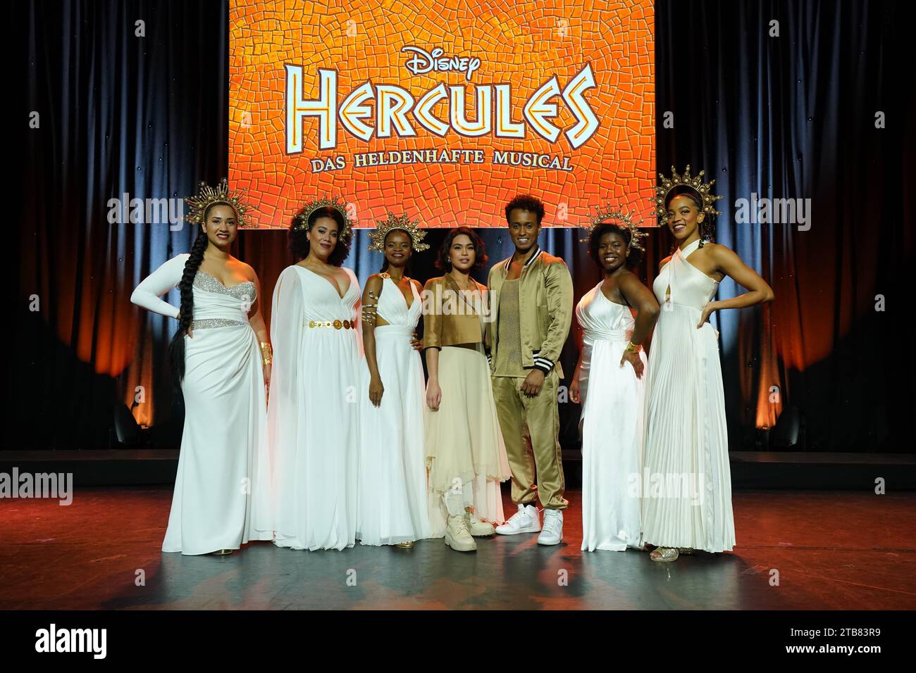 05 December 2023, Hamburg: Musical theater actress Mae Ann Jorolan (4th from right) as Meg and musical theater actor Benet Monteiro (3rd from right) as Hercules stand with the actresses of the muses, Uzoh (l) as Clio, Chasity Crisp (2nd from left) as Thalia, Venolia Manale (3rd from left) as Terpsichore, Leslie Behann (2nd from right) as Calliope and Shekinah McFarlane as Melepomene after the press conference.from left) as Terpsichore, Leslie Behann (2nd from right) as Calliope and Shekinah McFarlane as Melepomene are on stage at the Kehrwieder Theater in the Speicherstadt after the press pres Stock Photo