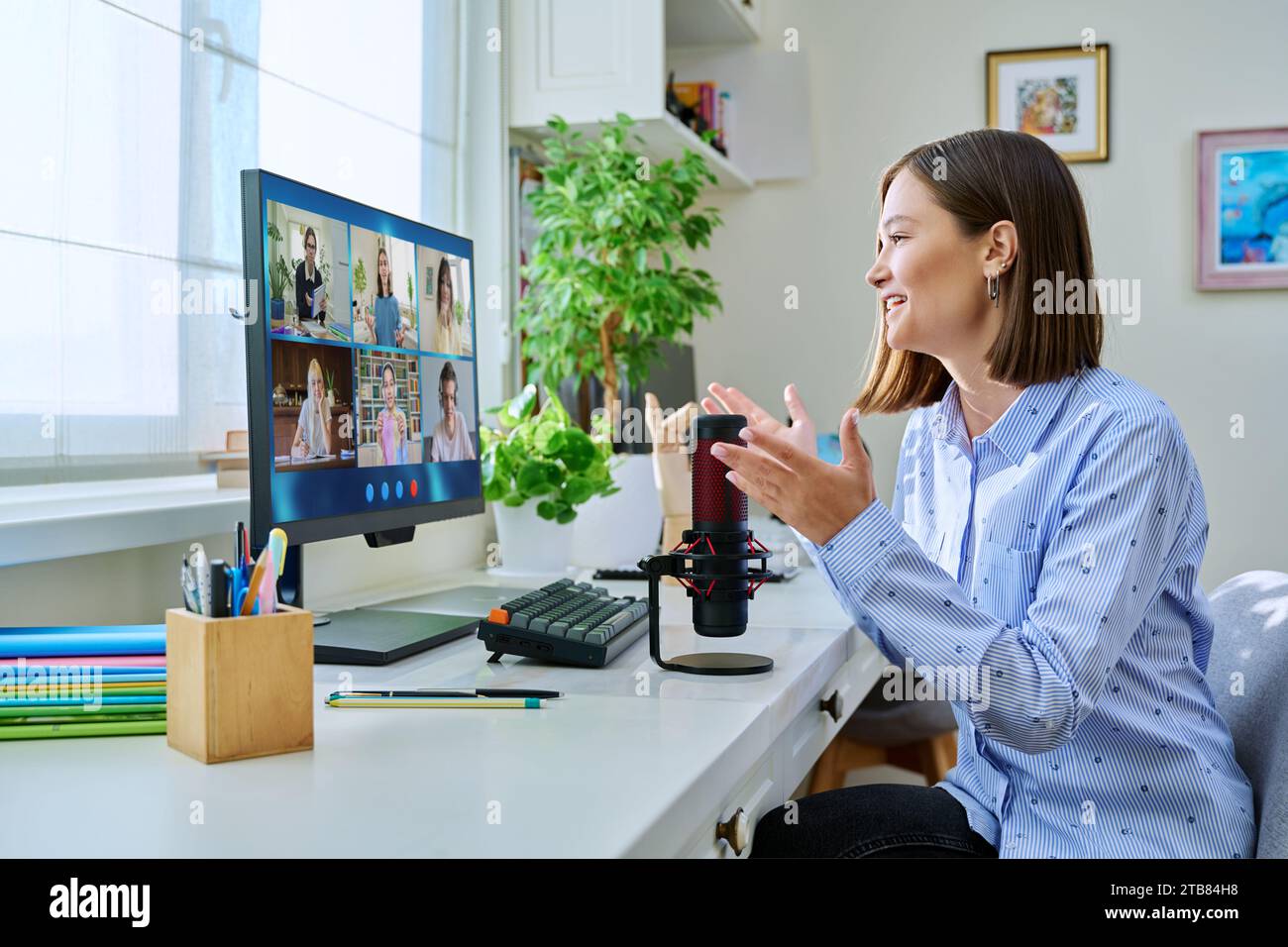 Young female teacher having video conference with group of teenage ...