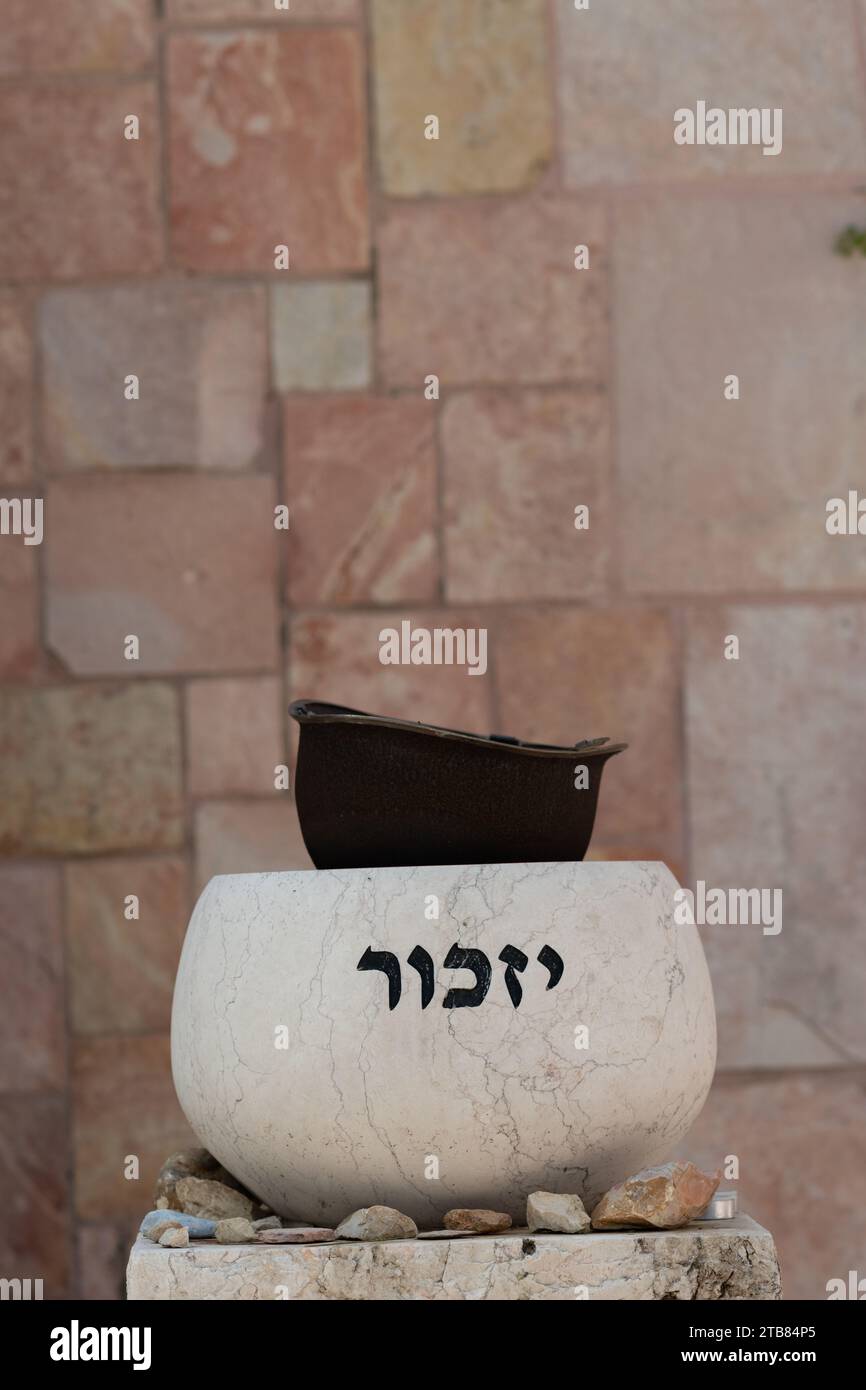 A stone marker holding an old soldier's helmet is engraved with the