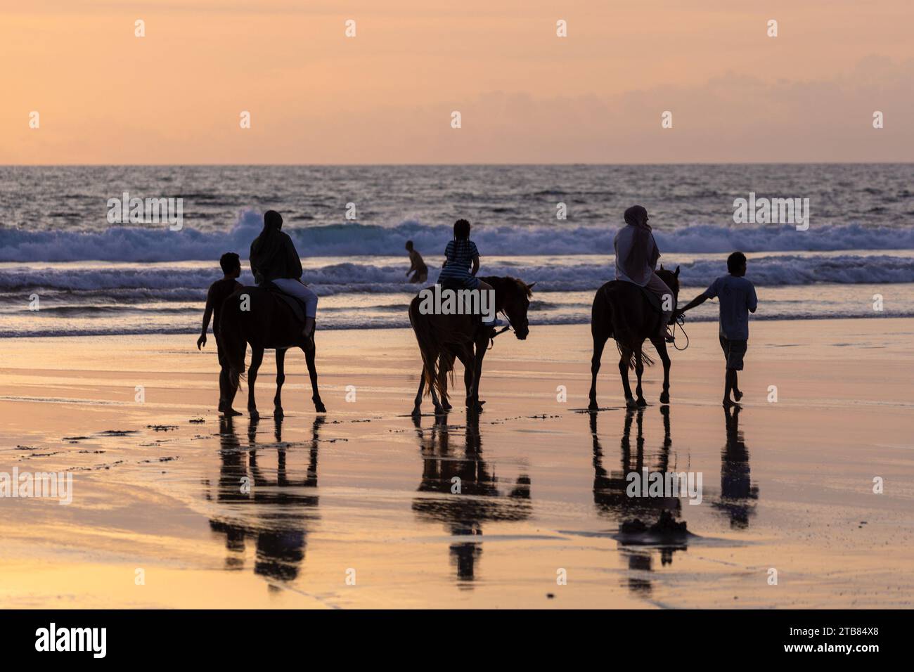 Horse riders on the beach in Seminyak at sunset, Bali Island, Indonesia ...