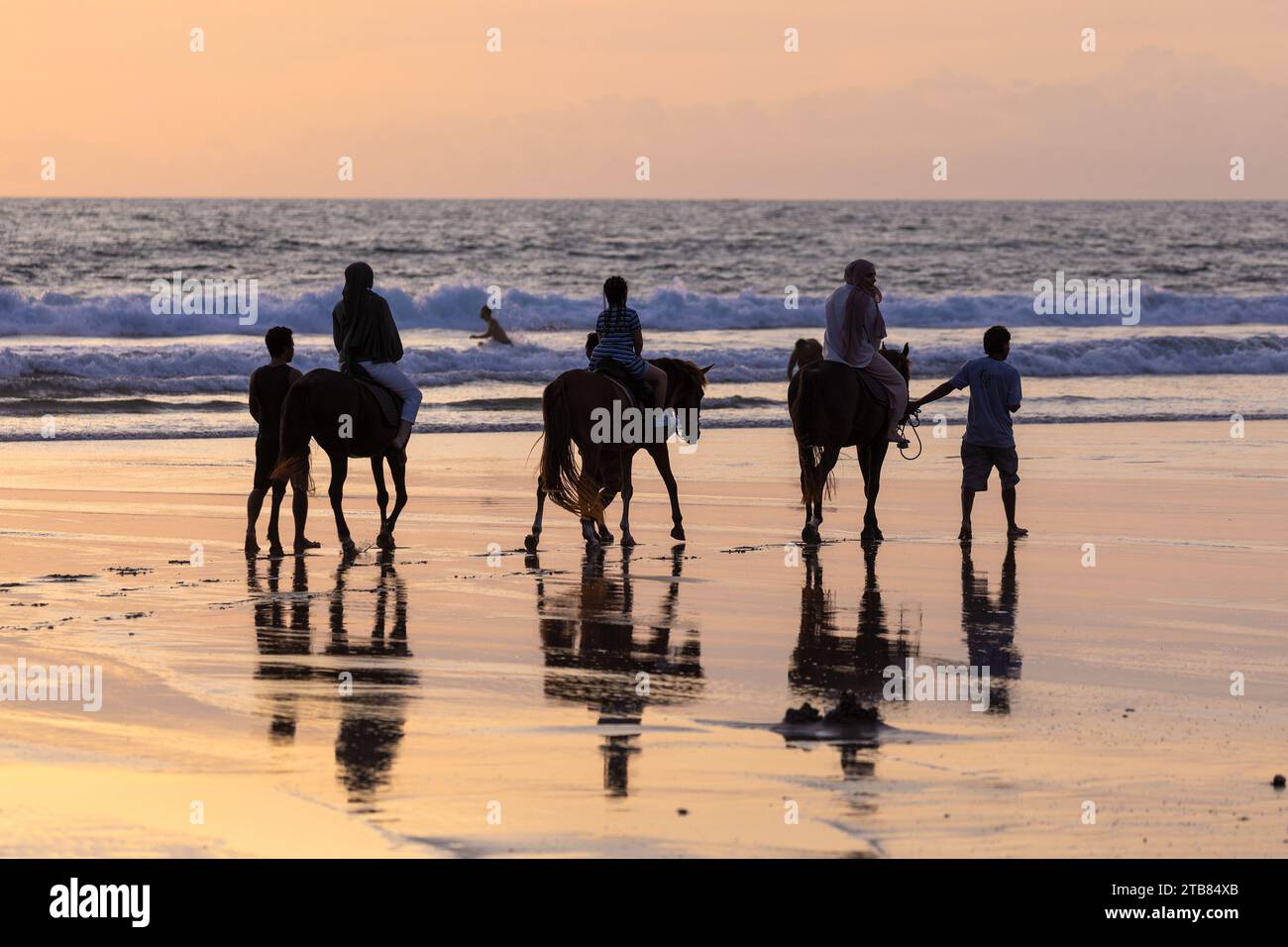 Horse riders on the beach in Seminyak at sunset, Bali Island, Indonesia ...