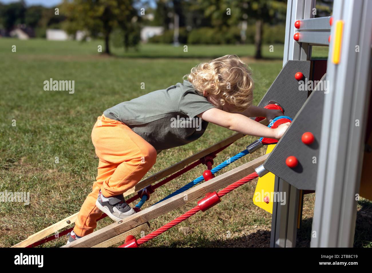 A little boy climbs on a slide in the children's playground Stock Photo